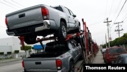 A carrier trailer transports Toyota cars for delivery while queuing at the Mexican border customs control to cross into the U.S.