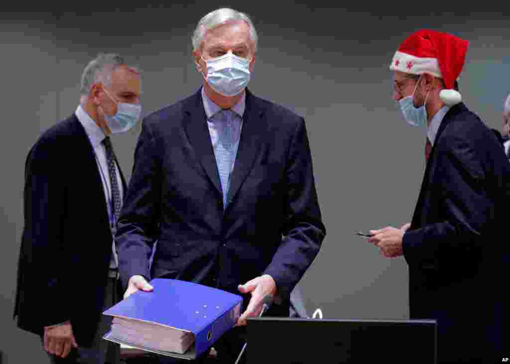  مذاکره کننده ارشد توافق تجاری اروپا با بریتانیا و یکی از همکارانش که کلاه کریسمسی به سر دارد روز کریسمس در شورای اروپا حضور یافتند.