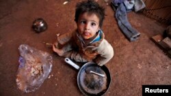 Một đứa trẻ tị nạn Syria ăn bên trong lều của gia đình mình tại một khu định cư không chính thức ở Deir al-Ahmar, thung lũng Bekaa.