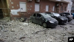 Damaged cars are parked in the yard amid debris after a Russian drone hit a multistory apartment house in Kyiv, Ukraine, Jan. 10, 2025. 