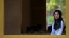 A Muslim invigilator stands near a window as students sit for their final examinations at the Sisowath High School in central Phnom Penh, Cambodia, August 22, 2016.