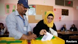 A Jordanian woman casts her ballot at a polling station for municipal elections in Amman, Jordan, Aug. 15, 2017.