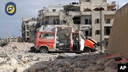 In this photo provided by the Syrian Civil Defense group known as the "White Helmets," a destroyed ambulance is seen outside the Syrian Civil Defense main center after airstrikes in Ansari neighborhood in the rebel-held part of eastern Aleppo, Syria, Sept