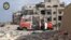 FILE - In this photo provided by the Syrian Civil Defense group known as the White Helmets, a destroyed ambulance is seen outside the Syrian Civil Defense main center after airstrikes in Ansari neighborhood in the rebel-held part of eastern Aleppo, Syria, Sept. 23, 2016.