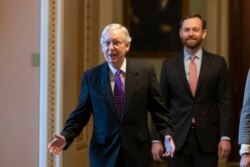 Senate Majority Leader Mitch McConnell of Ky., left, walks from the Senate Floor on Capitol Hill, Feb. 4, 2020 in Washington.