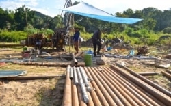 Workers operate a drill to test the bedrock for construction of the Luang Prabang dam near Houaygno village. (Zsombor Peter/VOA)