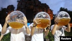 Para peserta kompetisi minum bir dari akuarium di Hangzhou, Provinsi Zheijiang, China, 21 Juli 2018. 