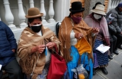 Women knit while waiting for their shot of the AstraZeneca vaccine for COVID-19 at a government-run social security clinic during vaccinations for people older than 80 in La Paz, Bolivia, April 14, 2021.