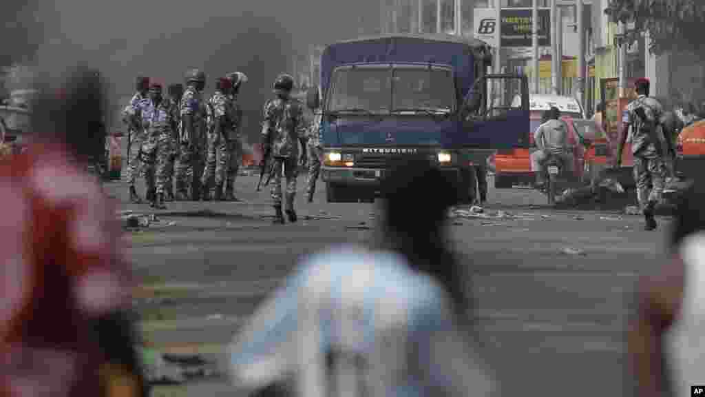 Des habitants des environs contemplent à distance les forces de sécurité dans le quartier de Koumassi à Abidjan, 6 décembre 2010.