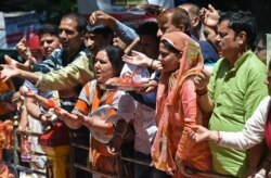 FILE - Kashmiri Hindu (Pandit) offer alms at the Mata Kheer Bhawani Temple during its annual festival in the village of Tullamulla, some 20 km from Srinagar, June 10, 2019.