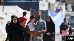 Palestinianos fogem do bairro residencial Hamad e dos seus arredores em Khan Yunis, no sul da Faixa de Gaza, depois de receberem um aviso do exército israelita para evacuarem a área, a 11 de agosto de 2024.