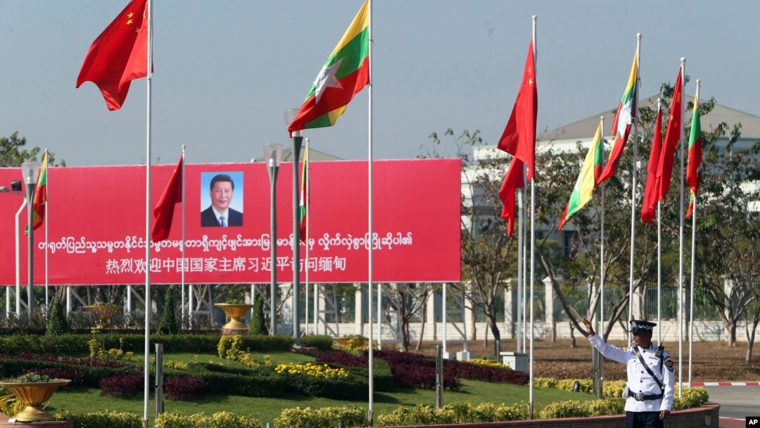 图为缅甸一名交警在欢迎习近平的标语牌旁执勤 (1月17日资料画面)
