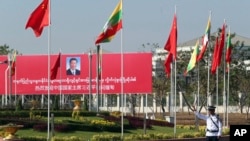 A traffic police stands on a road as he clears a road near a welcoming billboard to Chinese President Xi Jinping Friday, Jan. 17, 2020, in Naypyitaw, Myanmar. 