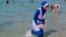 A woman wearing a burkini walks in the water August 27, 2016 on a beach in Marseille, France, the day after the country's highest administrative court suspended a ban on full-body burkini swimsuits that has outraged Muslims and opened divisions within the