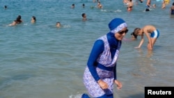 Seorang perempuan mengenakan burkini sedang berjalan di sebuah pantai di Marseille, Prancis. (Foto: Reuters)