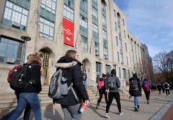 Sejumlah mahasiswa berjalan melewati pintu masuk ke Fakultas Seni dan Sains Universitas Boston, di Boston, Massachusetts, 29 November 2018. (Foto: AP)