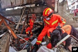 امدادگران با کمک سگ‌ به دنبال بازماندگان انفجار زیر آوار می‌گردند - ۱۳ ژوئن ۲۰۲۱
