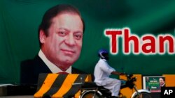 A motorcyclist drives past a billboard showing the portrait of Pakistani Prime Minister Nawaz Sharif at a main highway in Islamabad, Pakistan, July 10, 2017.