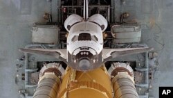 This image from 1996 shows space shuttle Atlantis as it began the slow journey to Launch Pad 39A from the Vehicle Assembly Building. This dramatic view looking directly down onto the shuttle atop the Mobile Launcher Platform and crawler-transporter was ta