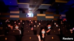 Warga Shanghai mulai bisa menonton film di bioskop dengan mengenakan masker, setelah pemerintah setempat membuka kembali gedung bioskop setalah ditutup berbulan-bulan akibat pandemi China, 20 Juli 2020. (REUTERS / Aly Song)