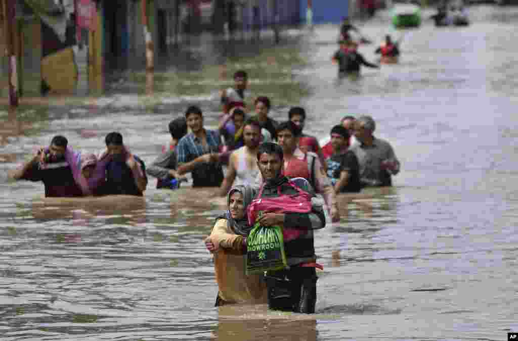 Kashmiri men evacuate women and the elderly from a flooded neighborhood in Srinagar, India, Sept. 7, 2014.