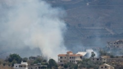 A photograph taken from the southern Lebanese village of Qabrikha shows smoke rising from burning fields in the and destroyed houses in the village of Bani Hayyan, during earlier Israeli military operations and now under it's control, some 10 kilometres f