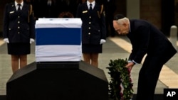 Presiden Israel Shimon Peres meletakkan karangan bunga di atas peti jenazah Sharon yang diletakkan di Knesset Plaza, gedung parlemen Israel di Yerusalem, Minggu (12/1). 