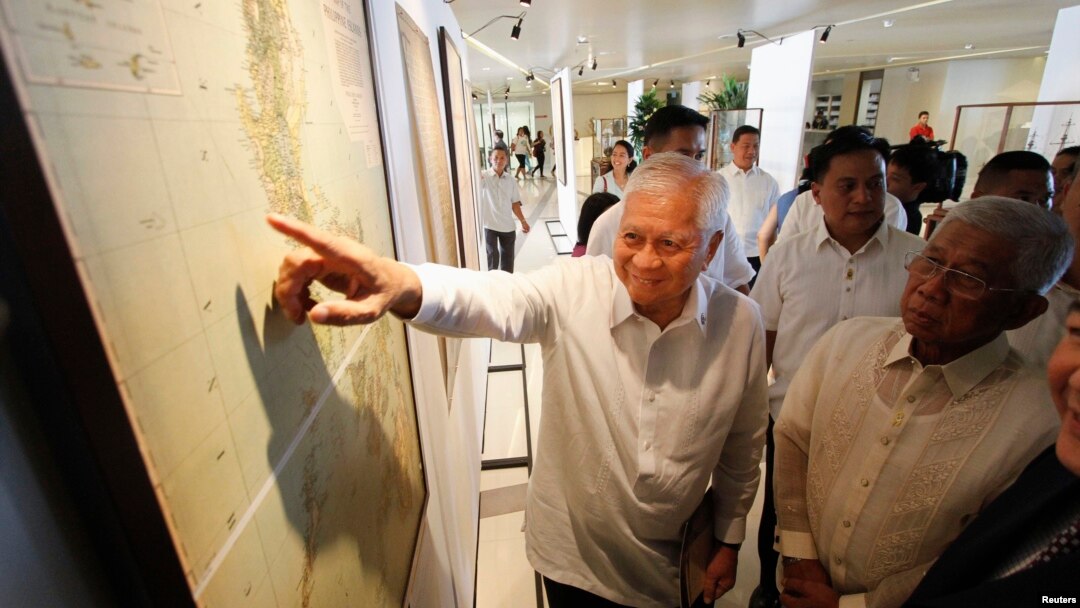Ngoại trưởng Philippines Albert Del Rosario chỉ vào một bản đồ cổ bên cạnh Bộ trưởng Quốc phòng Voltaire Gazmin tại một trường đại học Công giáo ở Manila.