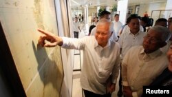 Ngoại trưởng Philippines Albert Del Rosario chỉ vào một bản đồ cổ bên cạnh Bộ trưởng Quốc phòng Voltaire Gazmin tại trường đại học Công giáo ở Manila.