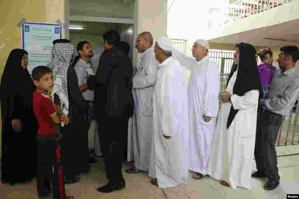 Residents stand in line as they wait to vote at a polling station during a parliamentary election in Baghdad April 30, 2014. Iraqis headed to the polls on Wednesday in their first national election since U.S. forces withdrew from Iraq in 2011, with Prime 