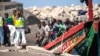 FILE - Migrants disembark from a wooden boat at the port in La Restinga on the Canary island of El Hierro, Spain, Aug. 18, 2024.