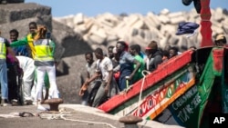 FILE - Migrants disembark from a wooden boat at the port in La Restinga on the Canary island of El Hierro, Spain, Aug. 18, 2024.