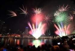 Crowds watch fireworks display during New Year's Eve celebrations in Brisbane, Australia, Dec. 31, 2019. (AAP Image/Dan Peled/via Reuters)