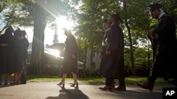 FILE - Graduates walk at a Harvard Commencement ceremony, May 29, 2022, in Cambridge, Massachusetts. 