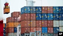  FILE- A container is loaded onto a cargo ship at the Tianjin port in China.