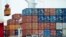  FILE- A container is loaded onto a cargo ship at the Tianjin port in China, Aug. 5, 2010. 