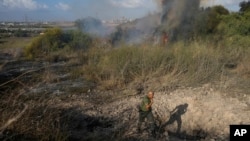 A police officer inspects the area around a fire after the military said it fired interceptors at a missile launched from Yemen that landed in central Israel on Sept. 15, 2024.