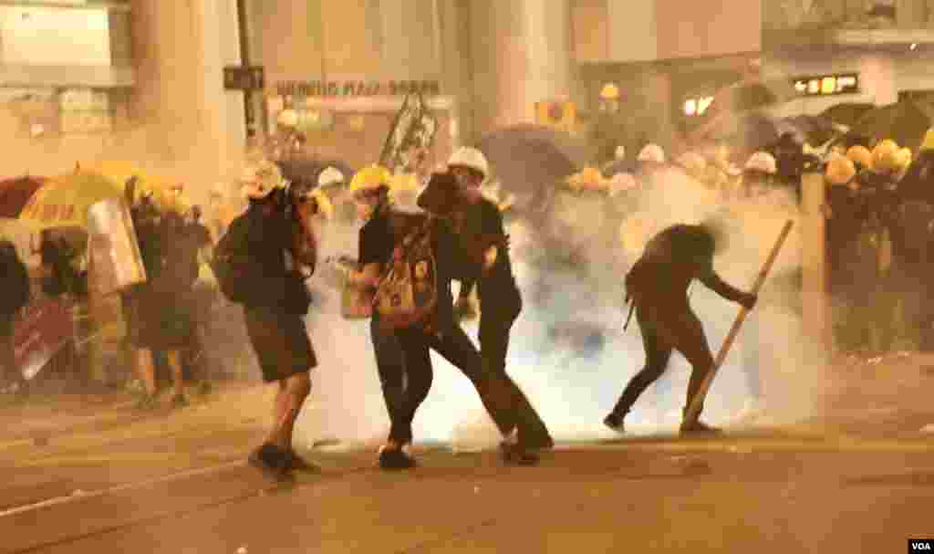 7月28日香港警方向德輔道中永安百貨對開集結的示威者人群施放催淚彈，示威者紛紛走避。 (美國之音湯惠芸拍攝) 