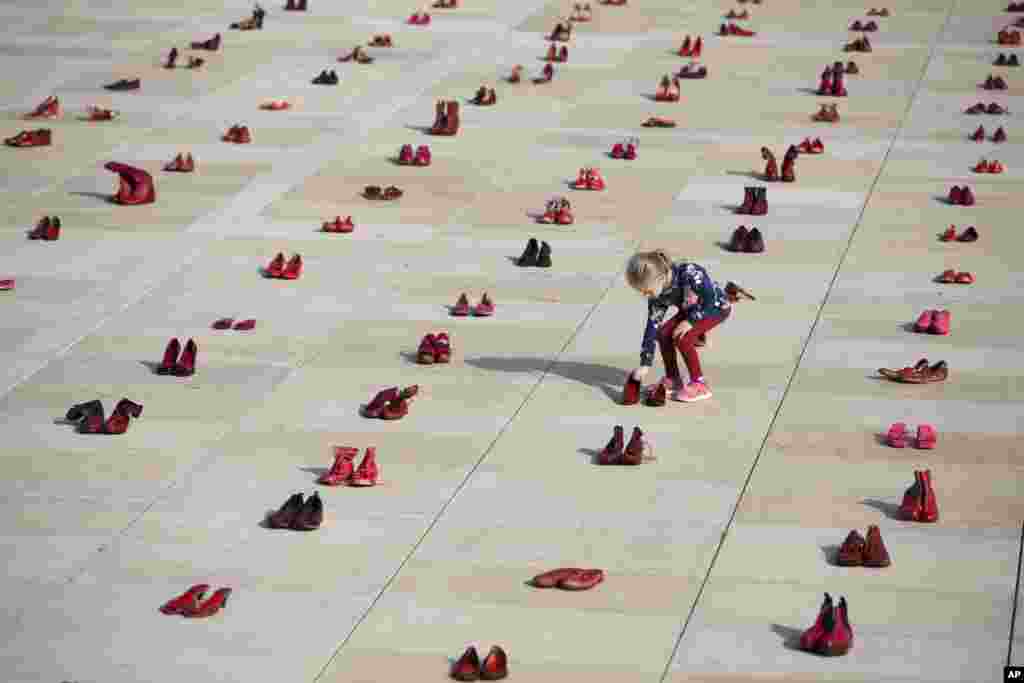 A display of hundreds of red shoes spread as protest against violence toward women in Israel at Habima Square in Tel Aviv.