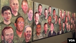 A panoramic view of paintings from former president George W. Bush's "Portraits of Courage" series is seen at the Bush Presidential Museum in Dallas, Texas (K. Farabaugh/VOA). Afghanistan war veteran Johnnie Yellock’s portrait is in the lower center of the first panel.