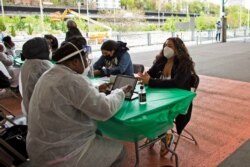 People check-in at a Covid-19 vaccination site at a sports center in Brooklyn, New York on May 8, 2021.