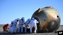 En esta fotografía publicada por la Agencia de Noticias Xinhua, trabajadores abren la cápsula de la nave espacial tripulada Shenzhou-17 tras su exitoso aterrizaje wn Dongfeng, en la Región Autónoma de Mongolia Interior, en el norte de China, el martes 30 de abril de 2024.