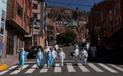 Vestidos con trajes protectores, un grupo de doctores van de casa en casa haciendo pruebas de Covid en Villa El Tejar, La Paz, Bolivia, el domingo 5 de julio de 2020.