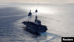 Japanese helicopter carrier Kaga, front, Japanese destroyer Inazuma, center, and British frigate HMS Argyll take part in a joint naval drill in the Indian Ocean, Sept. 26, 2018. 