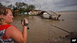 Seorang wanita merekam gambar dengan kamera video di wilayah Gelendzhik, selatan Rusia, yang tergenang banjir, Sabtu (7/7). 