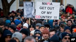 FILE - People march in silent protest in memory of murdered journalist Jan Kuciak and his girlfriend Martina Kusnirova in Bratislava, Slovakia, Feb. 28, 2018. In the wake of an unprecedented slayings of an investigative journalist and his fiancee, Slovakia turned in just few days from what seemed to be a stable European Union country into chaos. 