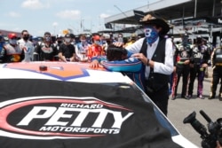 Driver Bubba Wallace, left, is overcome with emotion as team owner Richard Petty, comforts him as he arrives at his car in the pits of the Talladega Superspeedway prior to the start of the NASCAR Cup Series, June 22, 2020.