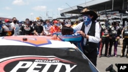 Driver Bubba Wallace, left, is comforted by team owner Richard Petty, as he arrives at his car in the pits of the Talladega Superspeedway prior to the start of the NASCAR Cup Series in Talladega Ala., Monday June 22, 2020. 