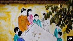 新疆和田團結新村一所住宅內顯示維吾爾和漢族男女共持五星旗的壁畫。(2018年9月20日)
