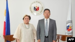 This handout photo taken on October 19, 2026 and released by the Department of Foreign Affairs shows Philippine Secretary of the Department of Foreign Affairs Maria Theresa Lazaro (L) and China's Ambassador to the Philippines Jing Quan.